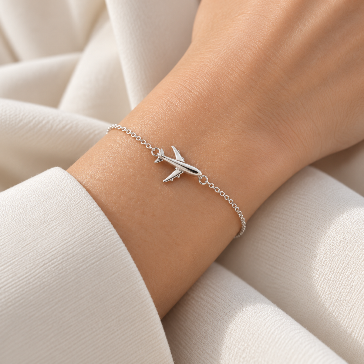 Silver airplane bracelet worn on wrist