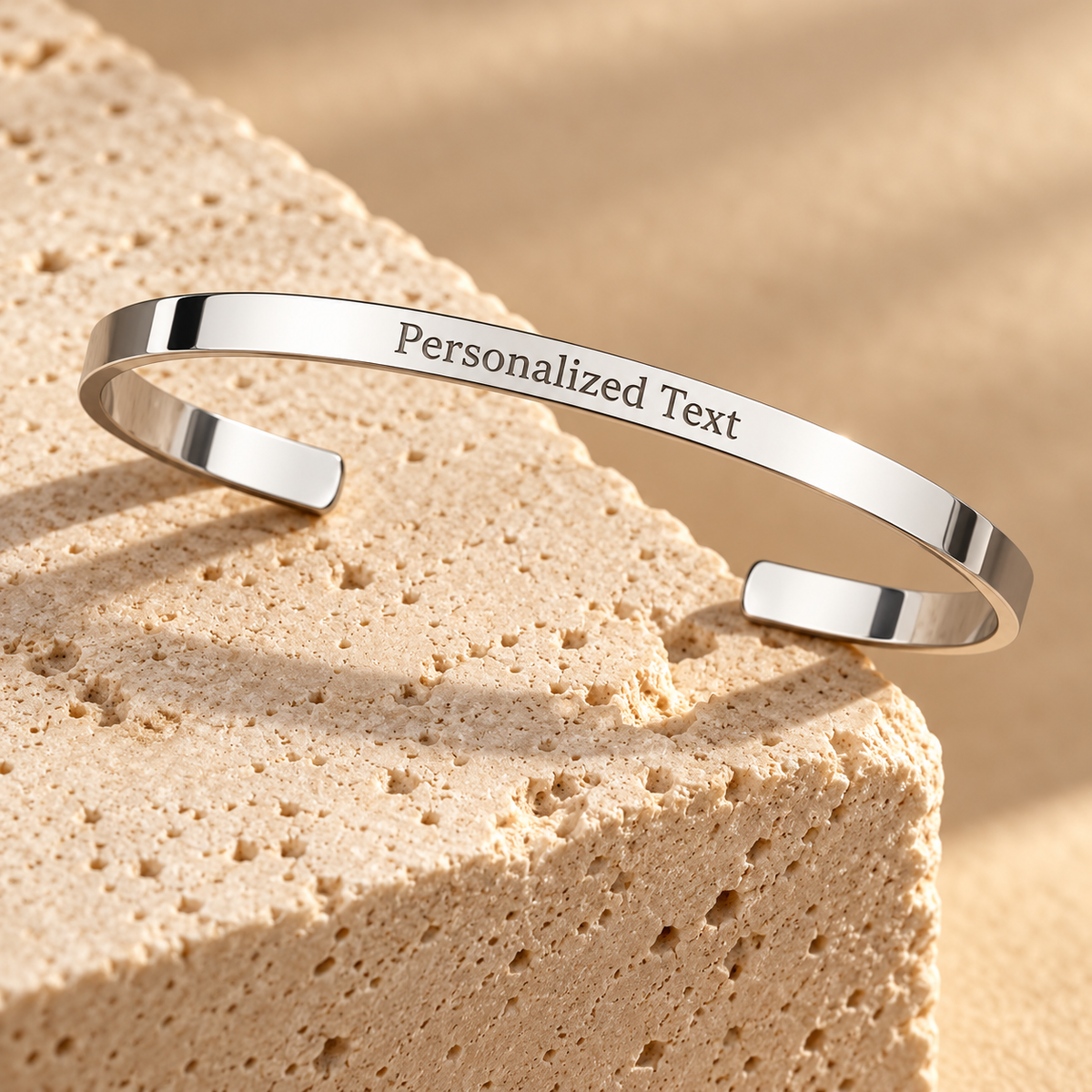 Engraved open silver cuff on travertine