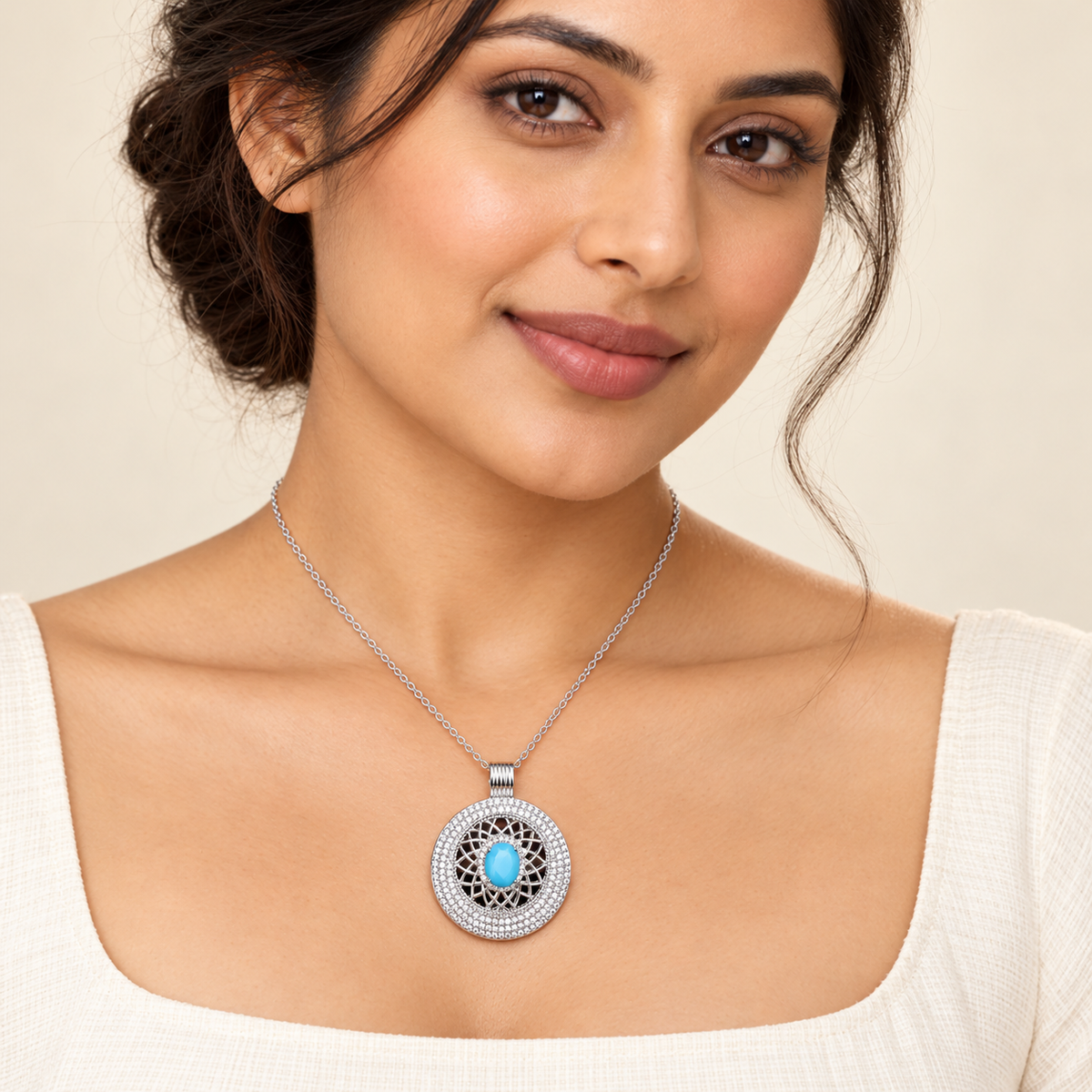 Aqua blue circular filigree pendant necklace on ivory outfit model