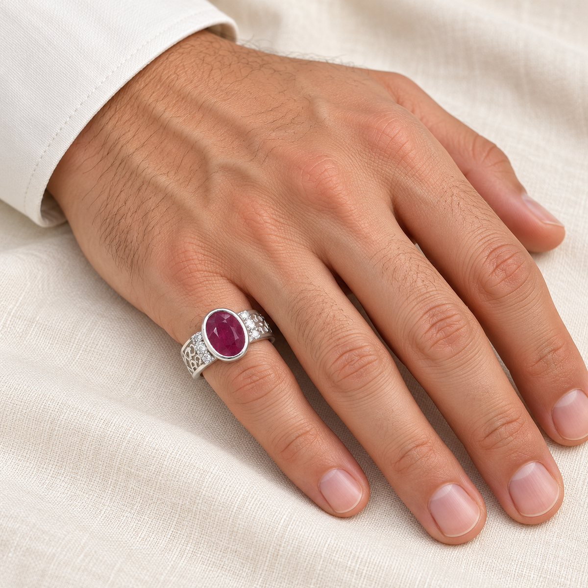 Oval ruby scroll silver ring worn on gentleman's right little finger