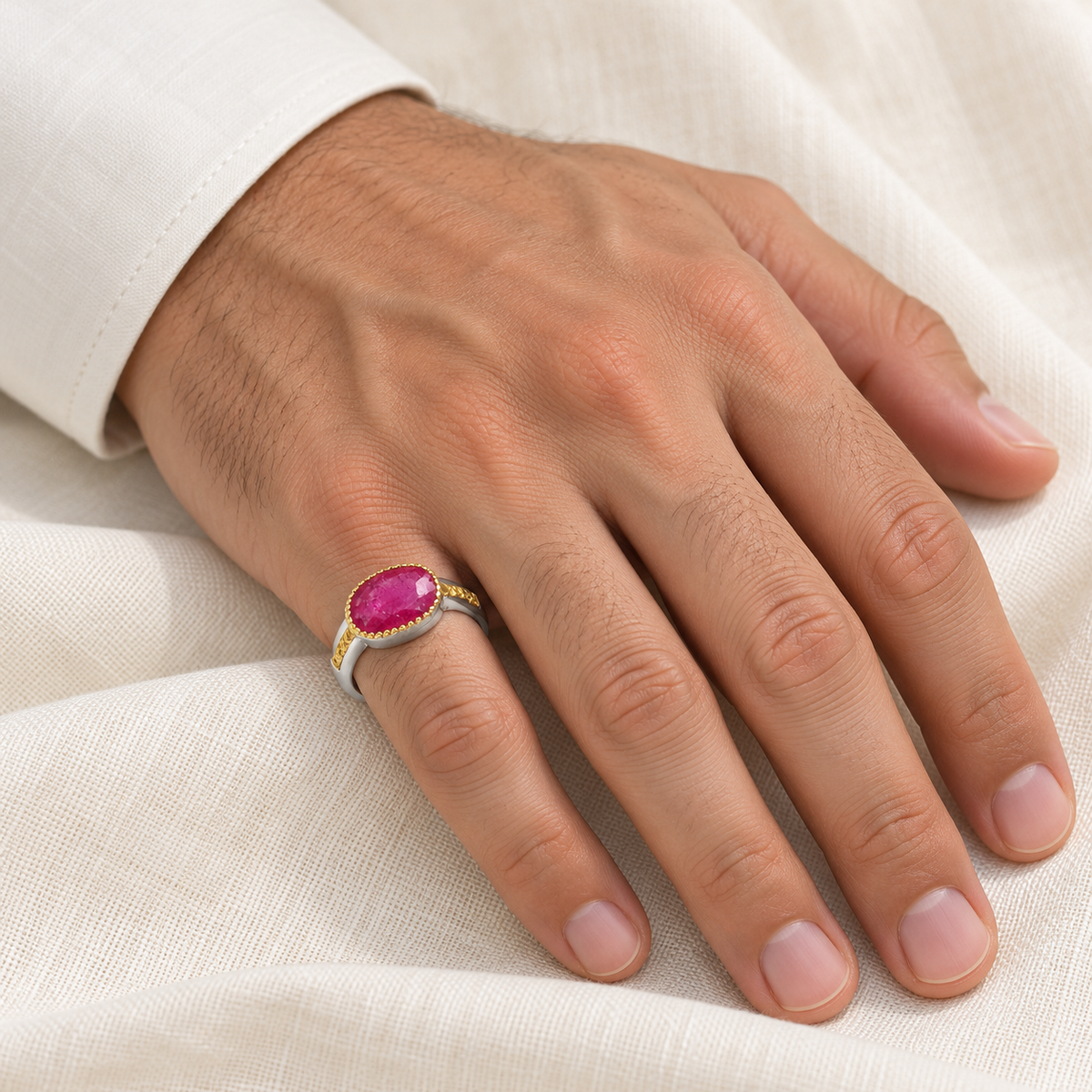 Oval pink-red two-tone ring on gentleman's right little finger