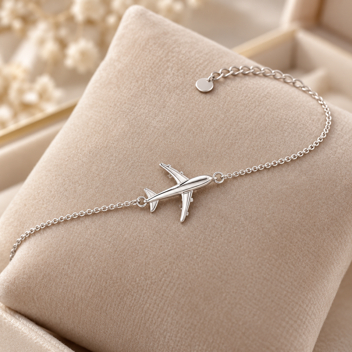 Silver airplane bracelet on beige velvet