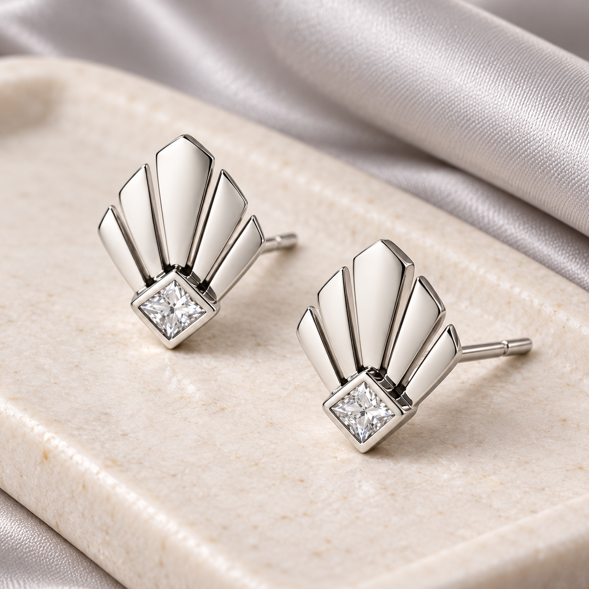 Silver fan stud pair on pale stone