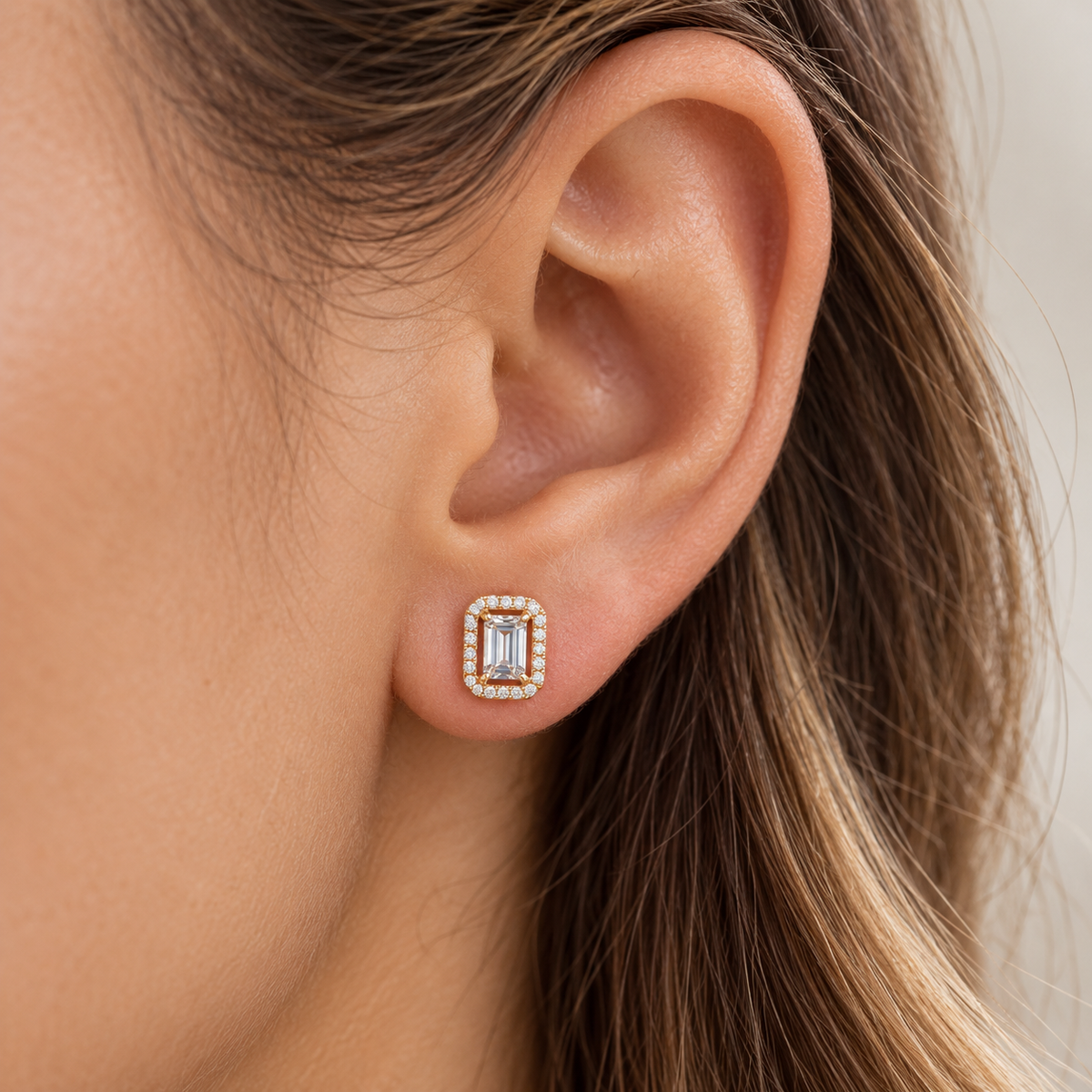 Model wearing rectangular halo stud earrings