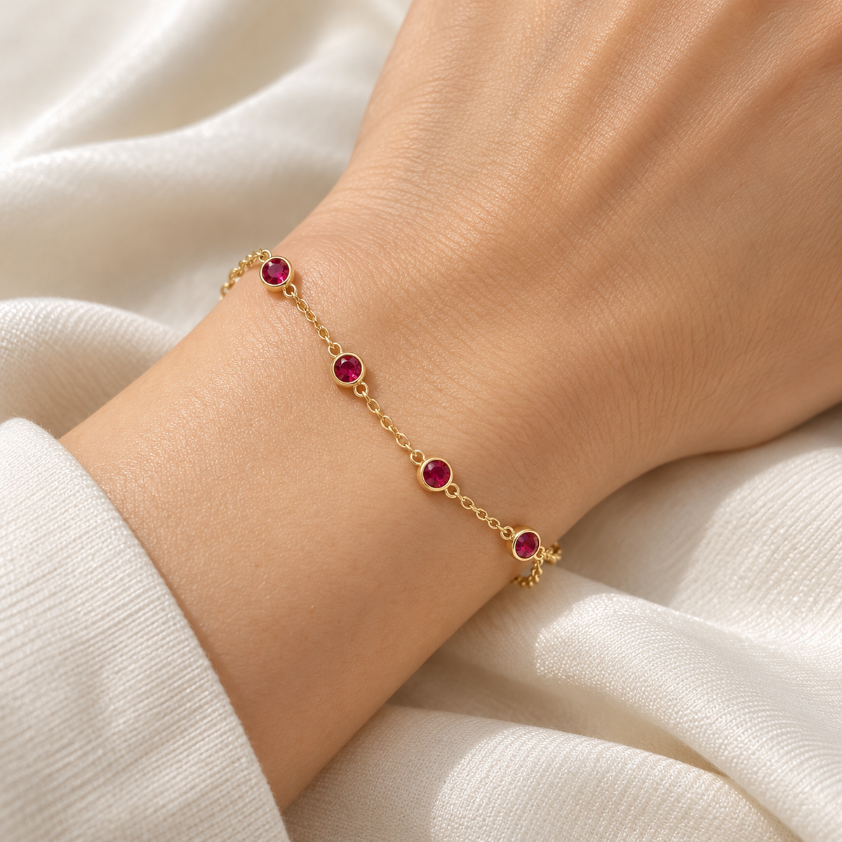 Gold red station bracelet on model wrist