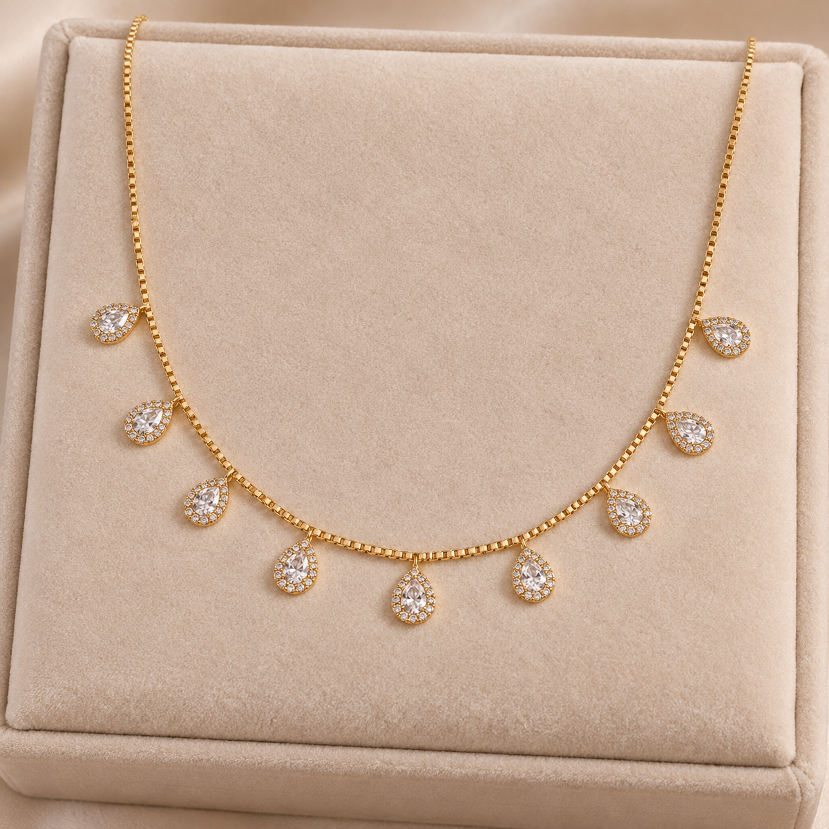 Golden teardrop halo matha patti on beige velvet display