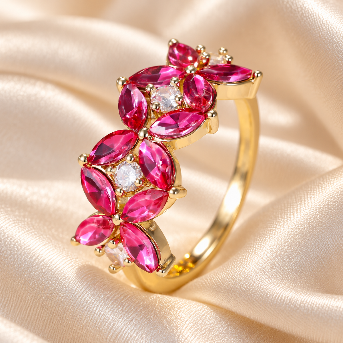 Pink-red floral gold-tone ring on ivory gown fabric